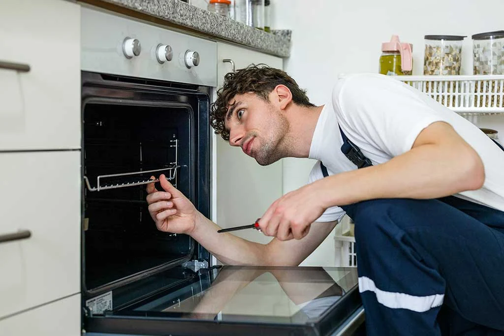 Technician checking an oven with a handheld diagnostic device