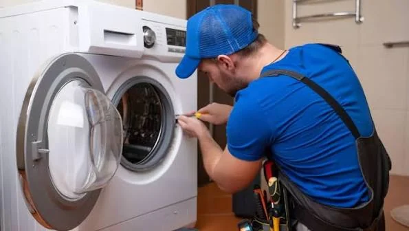 Technician inspecting the door and drum of a front-loading washing machine